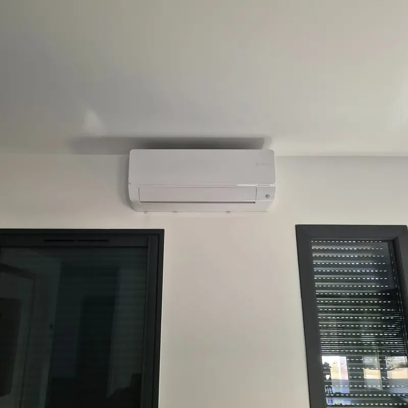 Climatiseur blanc au-dessus de deux baies vitrées