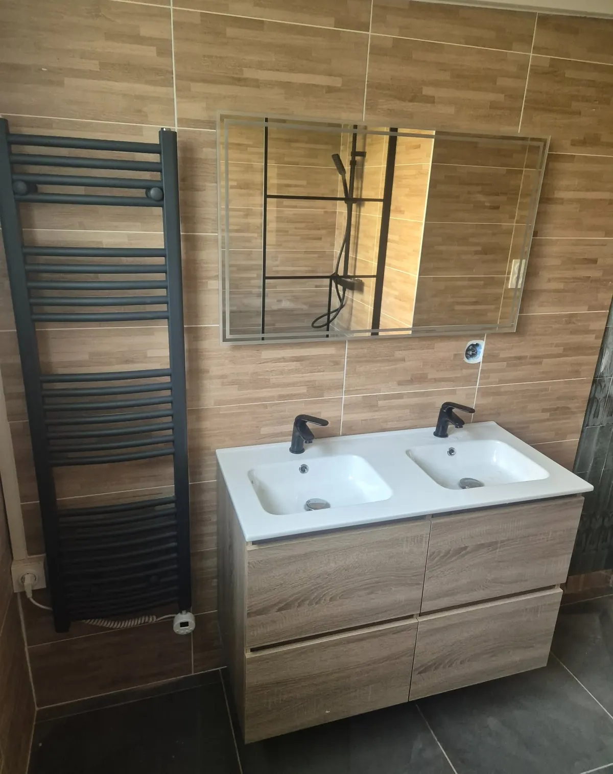 Après : douche derrière une verrière noire, double vasque et carrelage effet bois