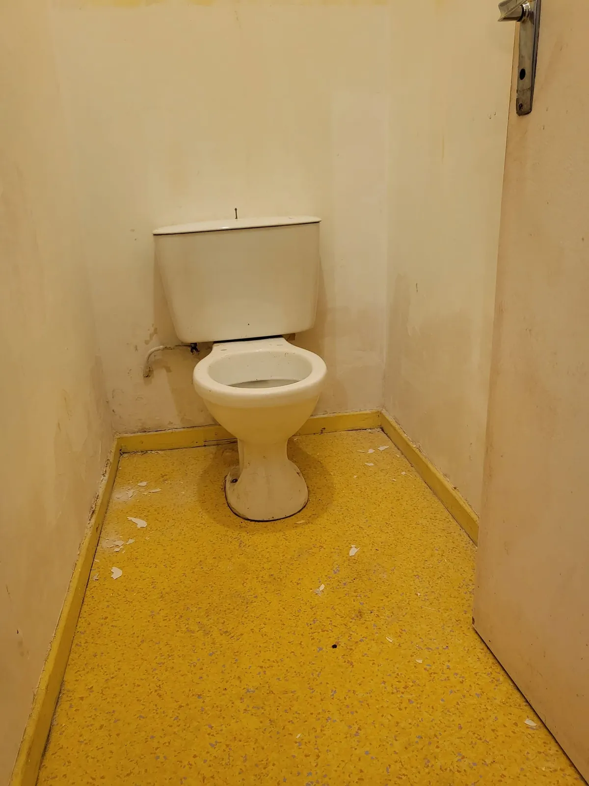 Avant : anciens WC aux murs jaunis, sol en lino jaune abîmé
