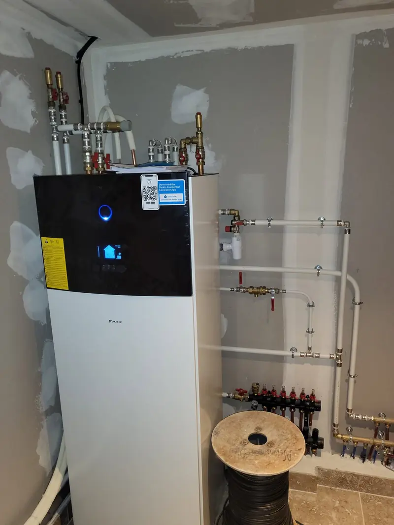 Chaufferie de maison neuve avec pompe à chaleur Daikin et collecteurs
